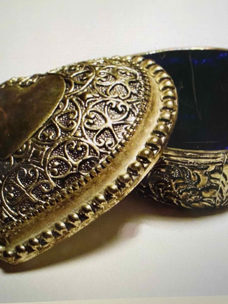 Small, silver jewelry box engraved with clouds swirling around dragons.